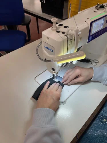 une couturière s'affaire à la fabrication d'un porte-monnaie upcyclé