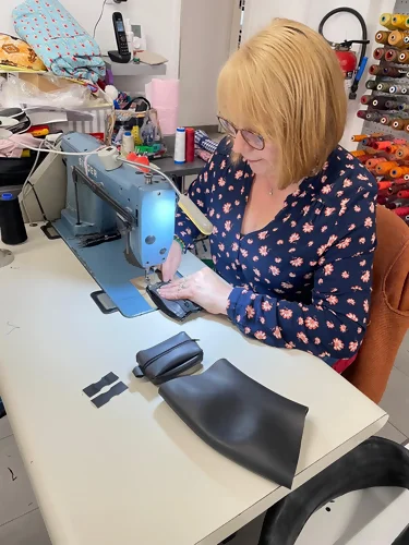 une couturière s'affaire à la fabrication d'un porte-monnaie upcyclé